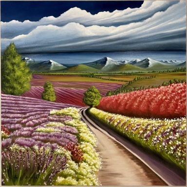 Champ de fleurs multicolores avec une route menant vers des montagnes sous un ciel nuageux.